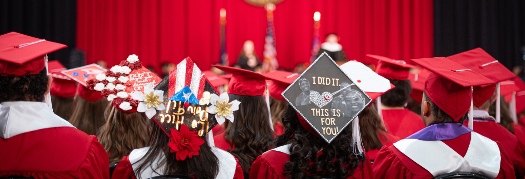 SVSU students sitting at commencement, facing away from the camera toward the stage.